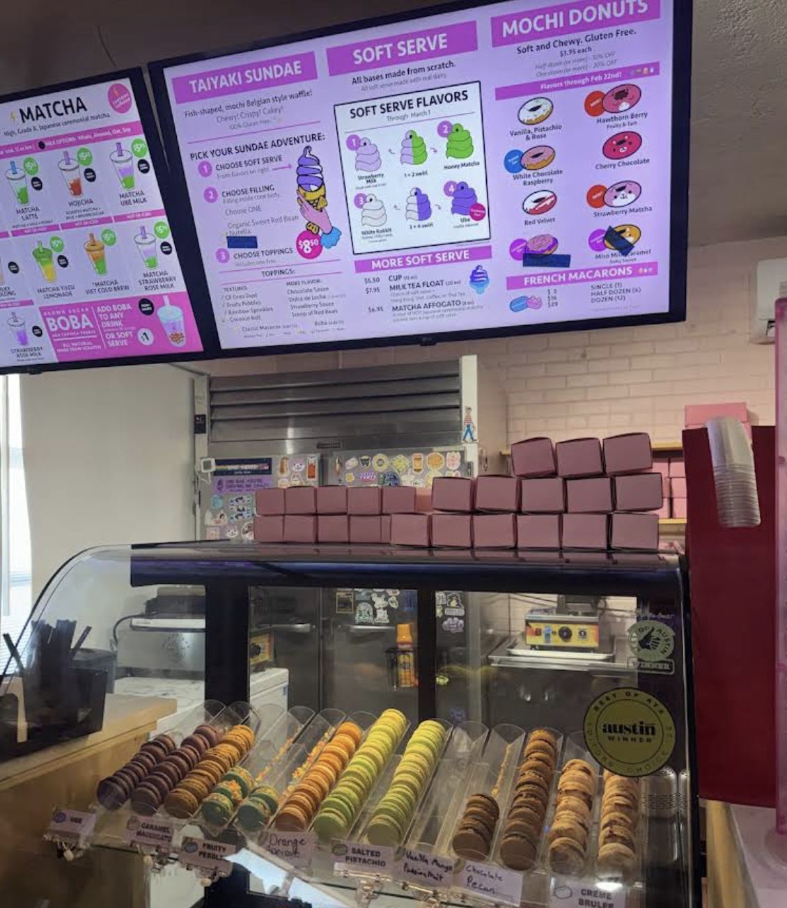 Menu boards at OMG Squee showing gluten-free mochi donuts and taiyaki sundaes