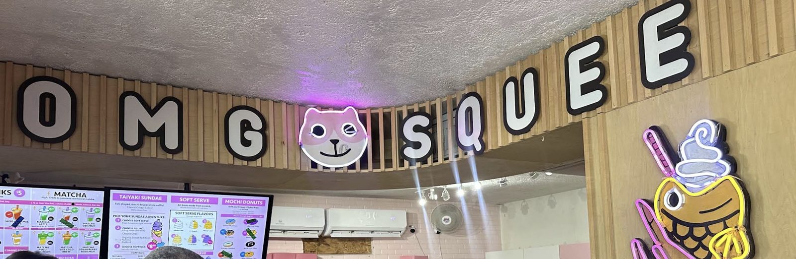 Counter and neon taiyaki sign inside OMG Squee